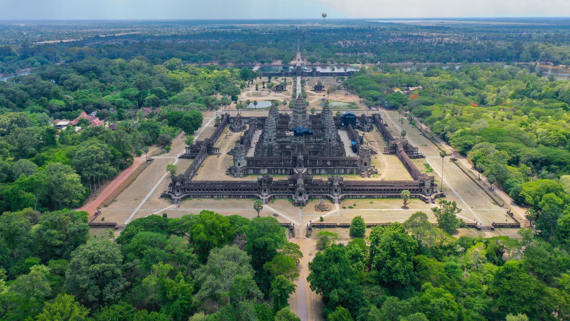 Aerial view of Angkor Wat's moated temple complex, its causeways and towers surrounded by green forest